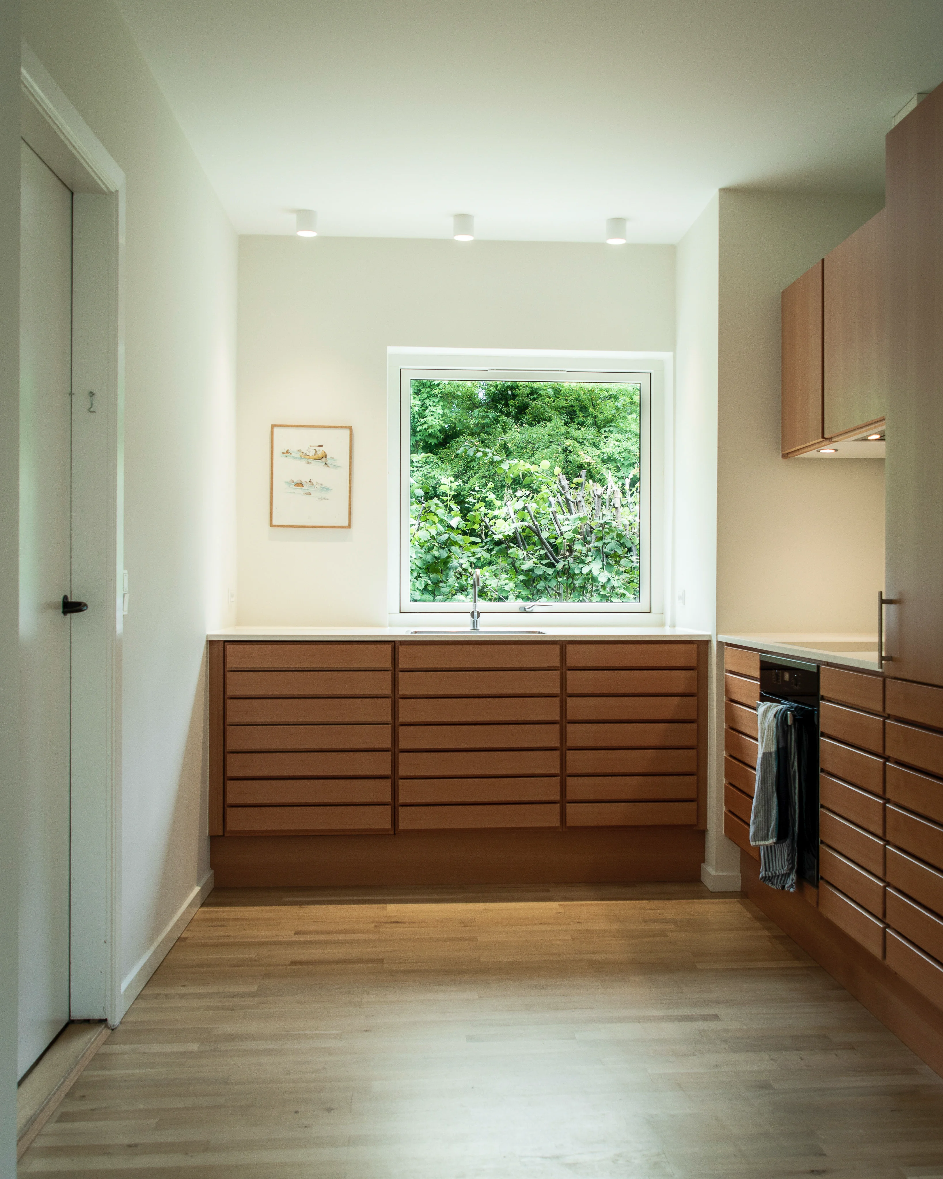 Opholdsrum i renoveret sen-60’er etplanshus – enkelt møblering og roligt farvetema.